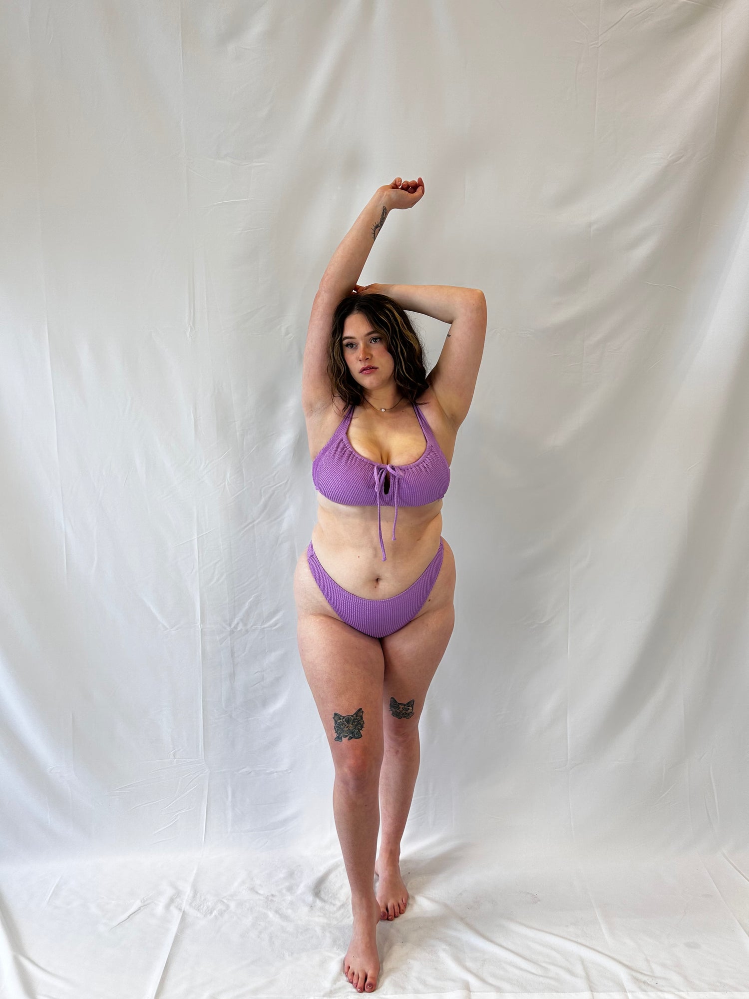 Model wears the lavender two piece bikini. Bikini top is the milkmaid style tie front crinkle fabric. Bikini bottom is the high rise cheeky textured crinkle fabric.