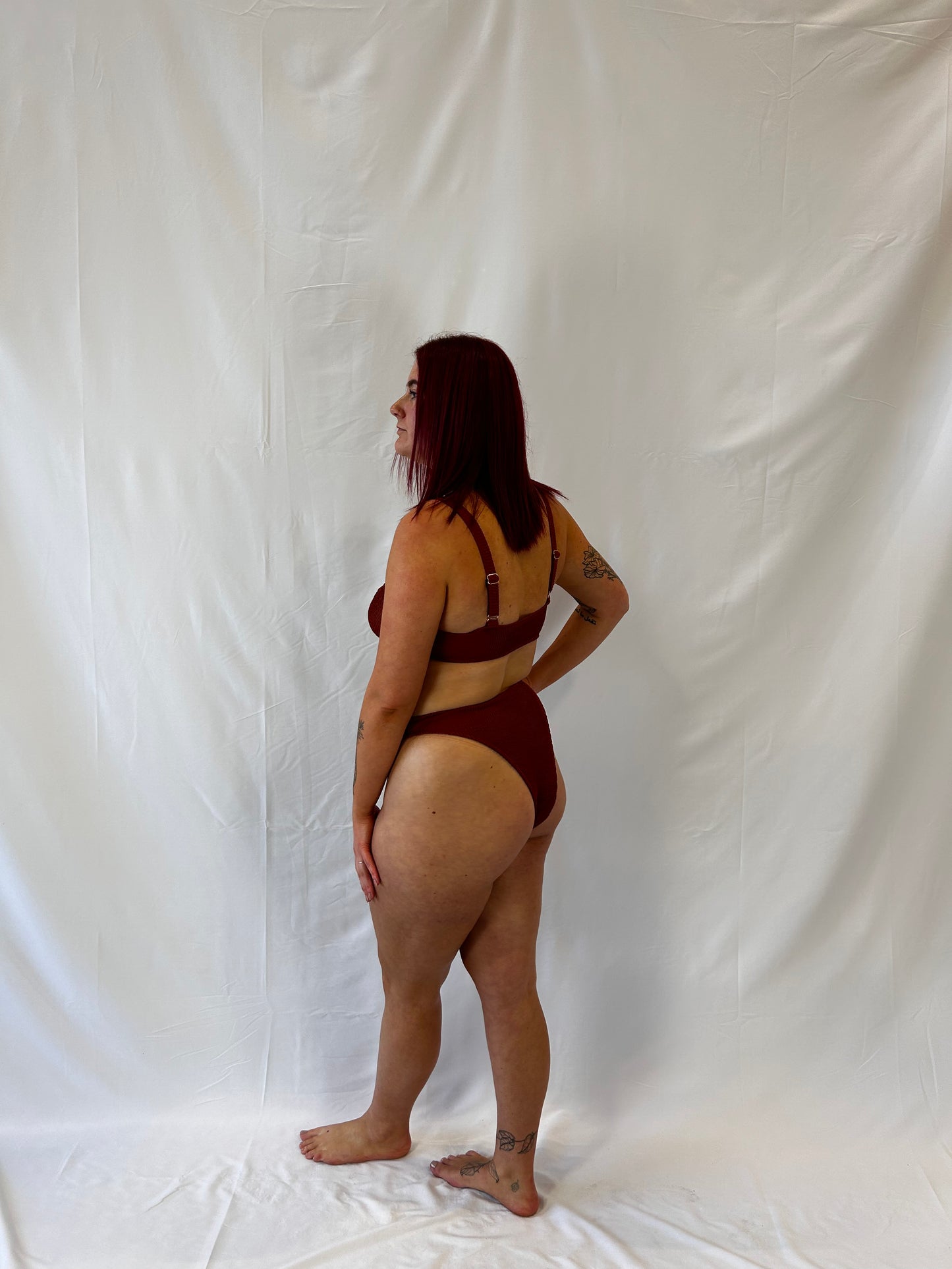 Side view of the rust two piece bikini. Bikini top is the milkmaid style tie front crinkle fabric. Bikini bottom is the high rise cheeky textured crinkle fabric.