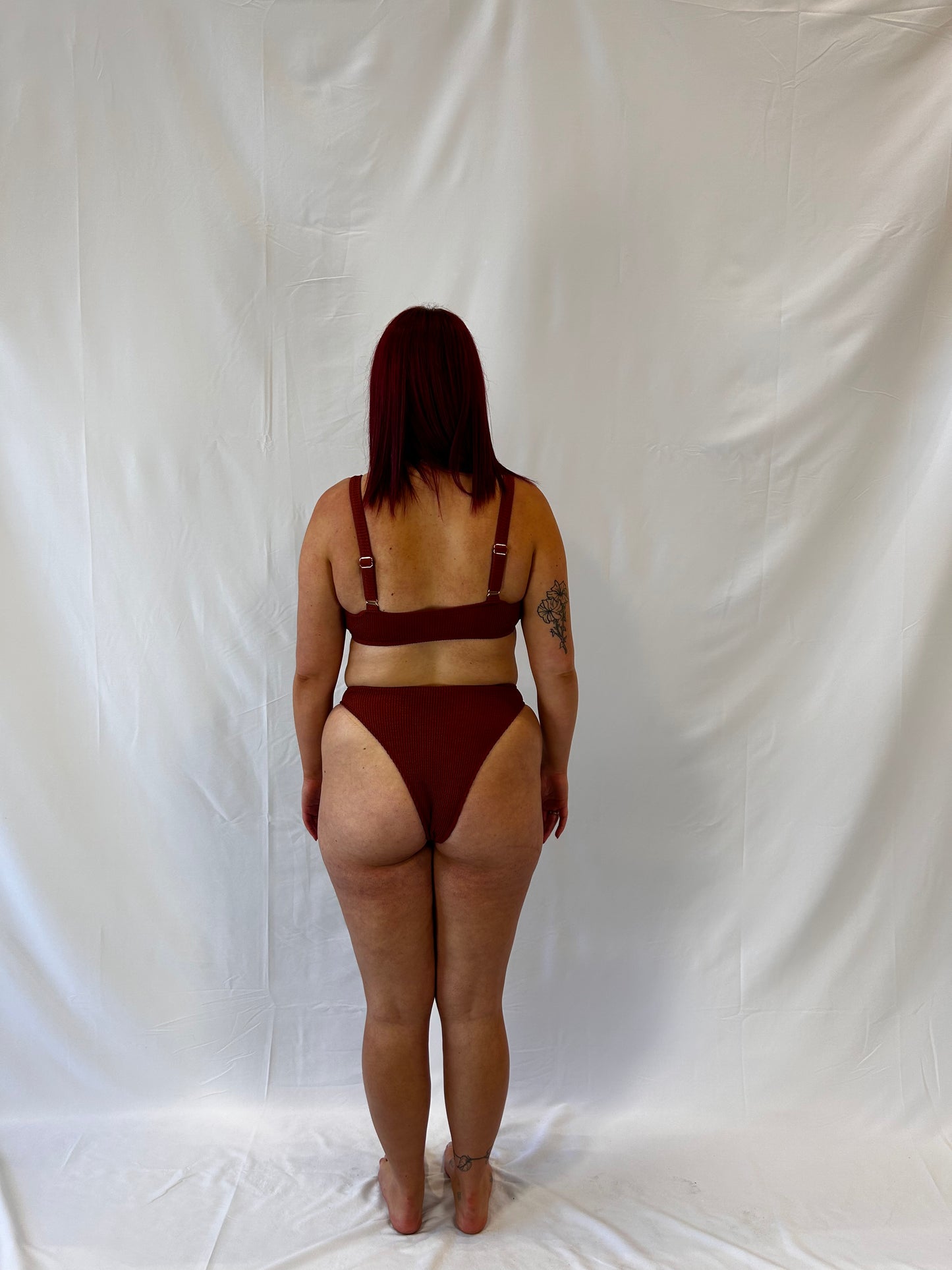 Rust two piece bikini from the back. Bikini top is the milkmaid style tie front crinkle fabric. Bikini bottom is the high rise cheeky textured crinkle fabric.