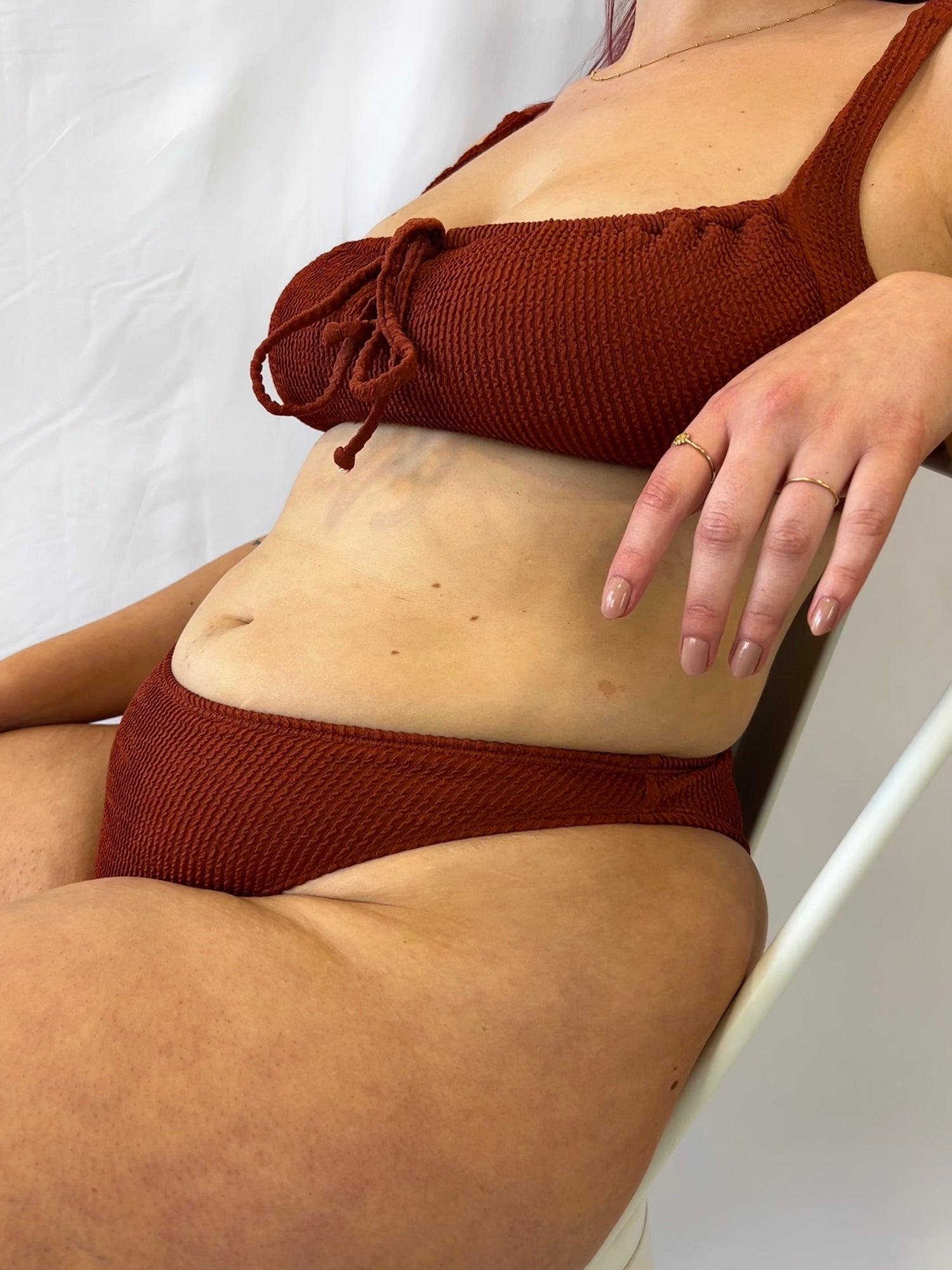 Close up of the rust two piece bikini from the side while sitting.