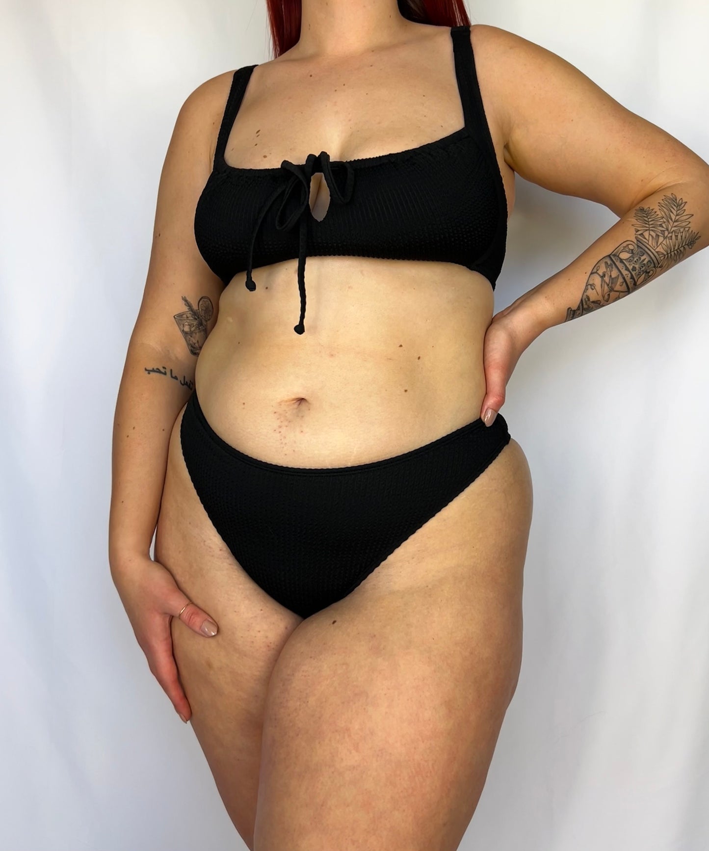 Model wears the high rise cheeky textured crinkle fabric bikini bottom. Close up of the black bikini bottom.