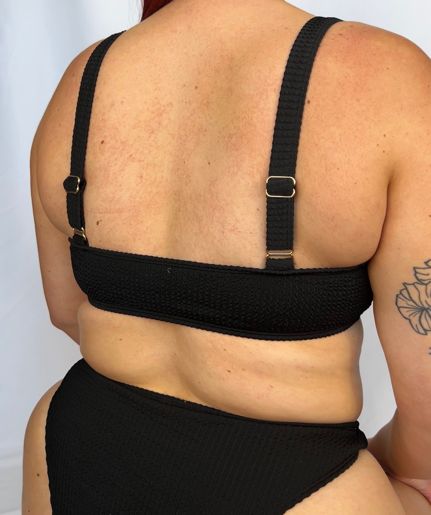 Model wears the milkmaid style tie front crinkle fabric bikini top. Close up of the two piece bikini top in black from the back